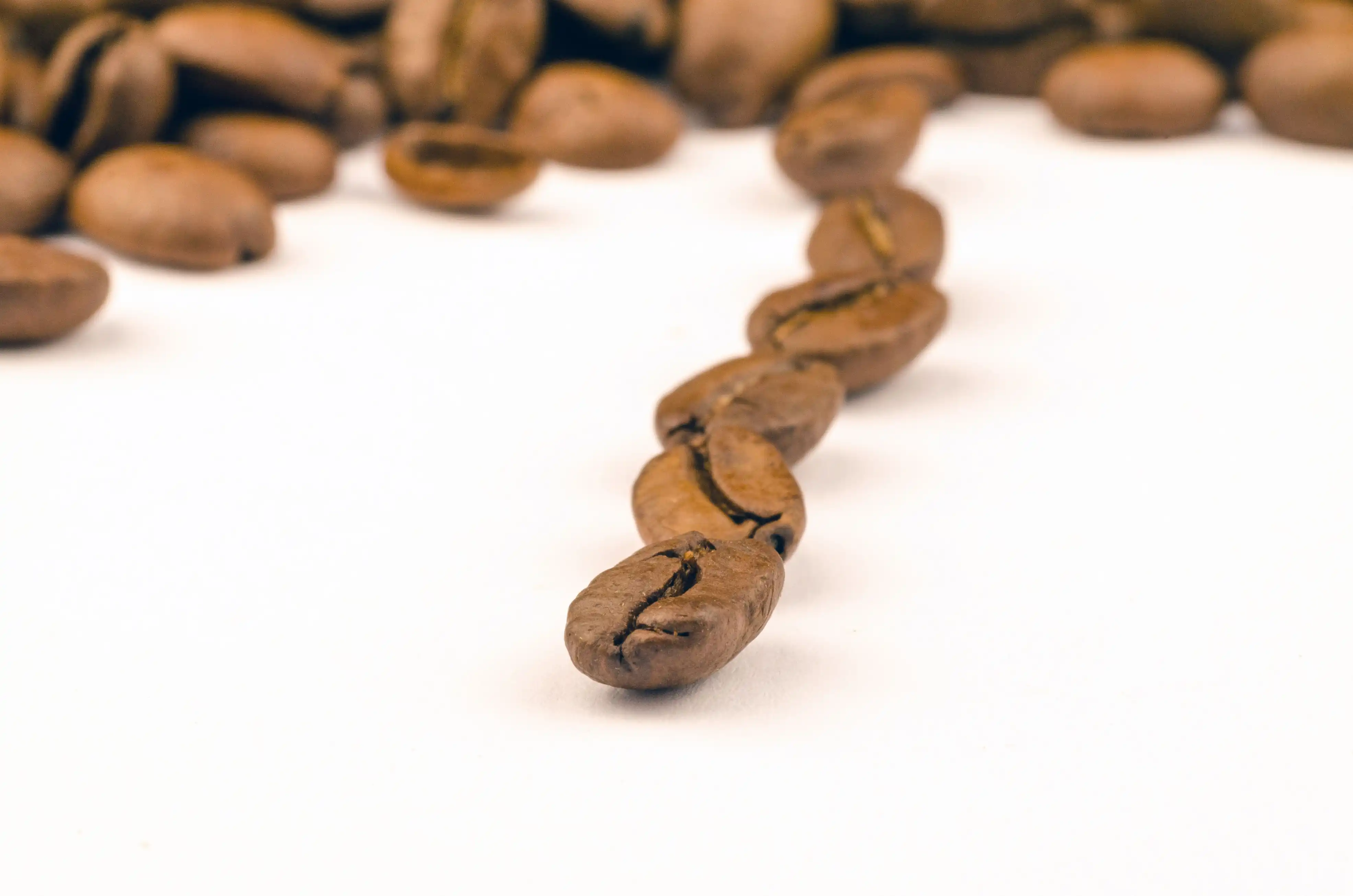 Close-up pile of roasted coffee beans on a white background